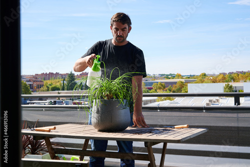 Obraz na plátne Male gardener caring about plant on terrace