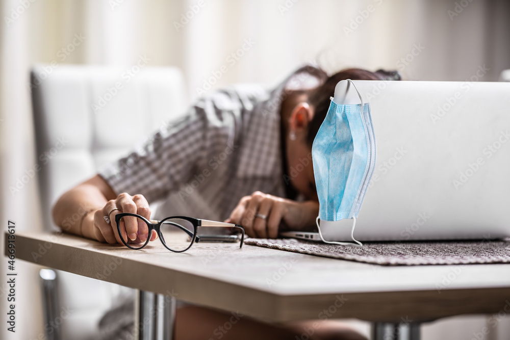 Unhappy woman collapses in front of her pc at home as remote home office causes depression and loneliness - obrazy, fototapety, plakaty 