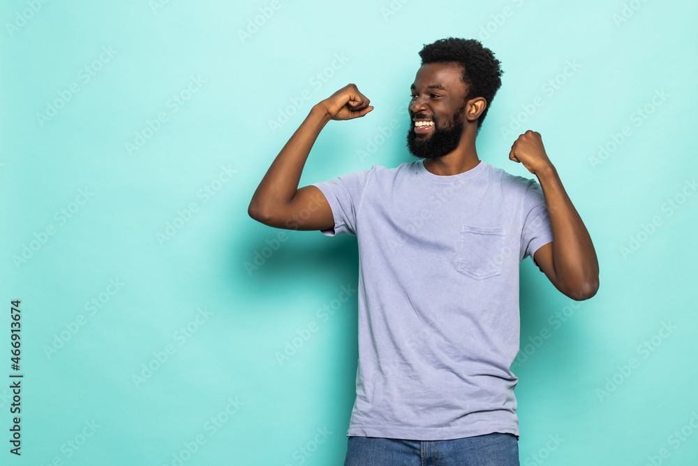 Photo of happy young africanman isolated over turquoisse background make winner gesture. Photo of happy young africanman isolated over turquoisse background make winner gesture.