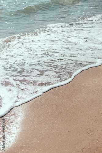 Soft wave of blue ocean on a sandy beach.