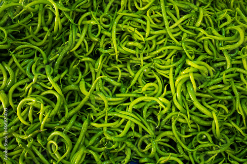 Close-up on a shelf with green peppers in the market.