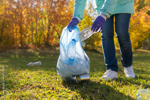 A female volunteer cleans plastic garbage in nature.