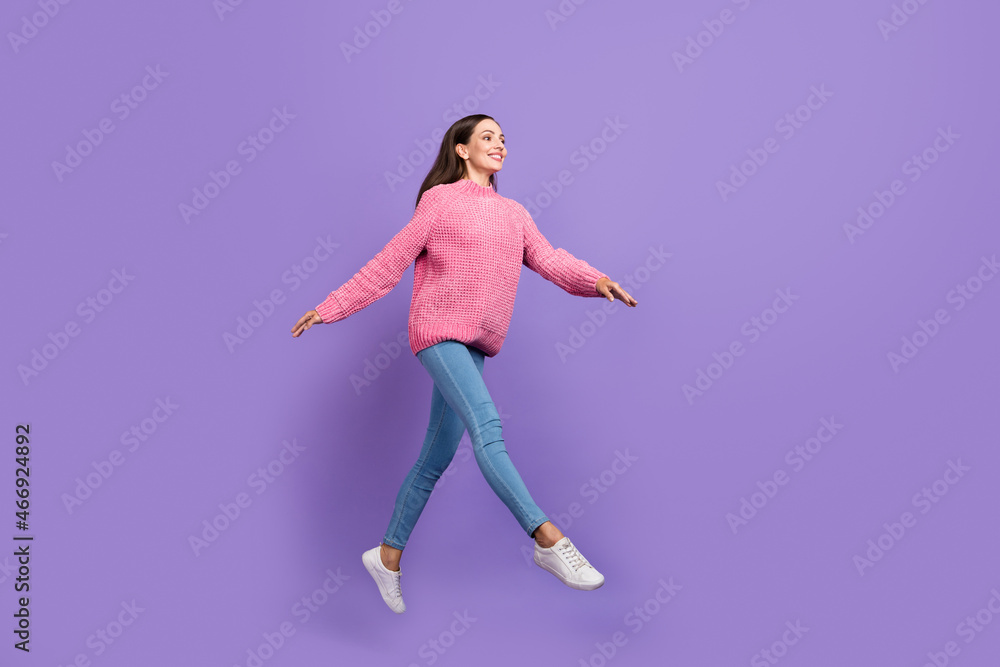 Full length photo of funny young lady run wear pullover jeans sneakers isolated on purple background Full length photo of funny young lady run wear pullover jeans sneakers isolated on purple background