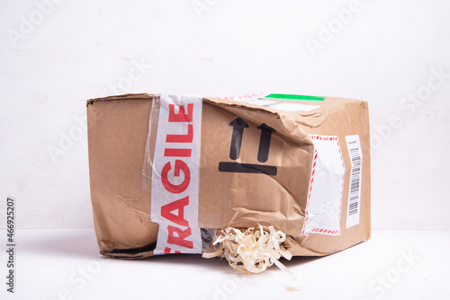 Broken cardboard box, fragille marked parcel