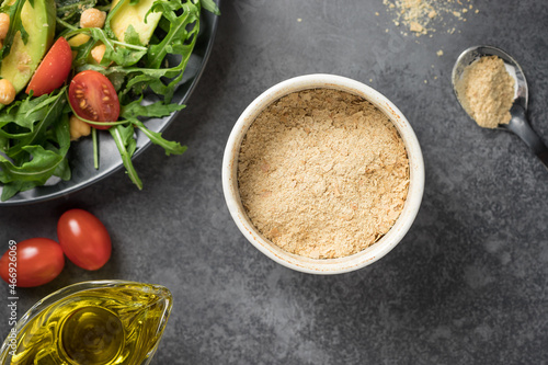 Nutritional yeast superfood in ceramic bowl. Plant-based food concept. closeup photo