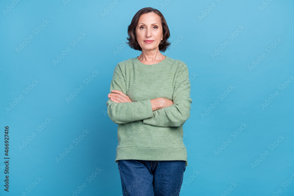 Photo of elder grey hair bossy woman crossed palms wear green pullover isolated on blue color background Photo of elder grey hair bossy woman crossed palms wear green pullover isolated on blue color background