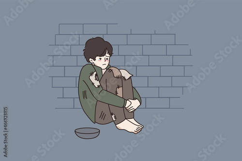 Poor unhappy small boy begging on street with empty bowl. Upset little homeless kid hungry sad ask for help or food outdoors. Poverty, children beggar concept. Vector illustration. Cartoon character. 