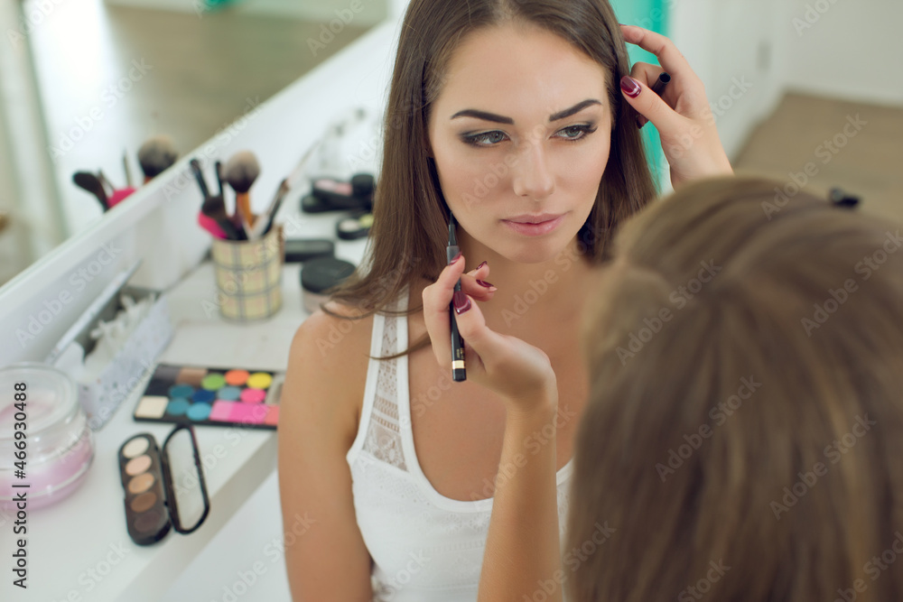 The girl makes a visage. Make-up for a woman. High quality photo The girl makes a visage. Make-up for a woman. High quality photo
