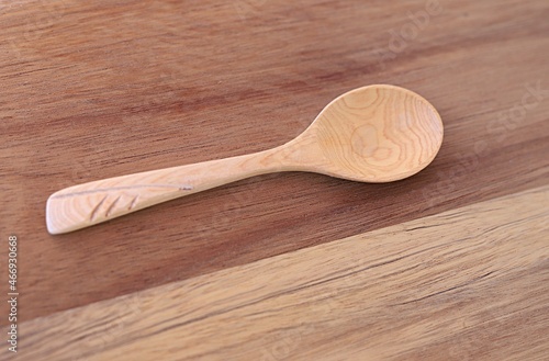 one empty upturned wooden spoon close-up on a wooden cutting board. template for a culinary recipe. cooking