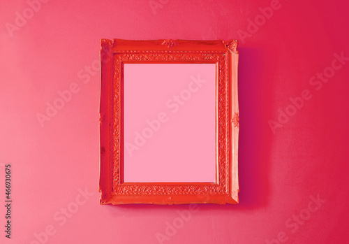 Scarlet red antique empty photo frame isolated on gradient raspberry red colored wall