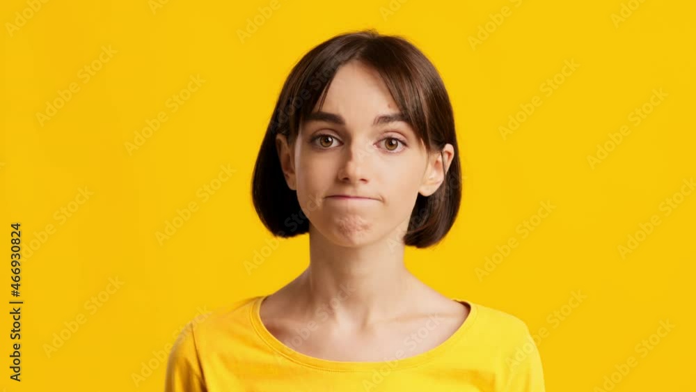 Clueless Young Female Making Shoulder Shrug Over Yellow Background Clueless Young Female Making Shoulder Shrug Over Yellow Background