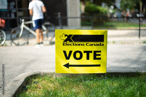 A yellow election sign directs people where to cast their voting ballot
