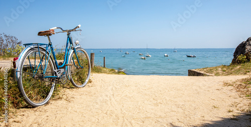 Vieux vélo bleu en bord de mer sur le littoral en France.