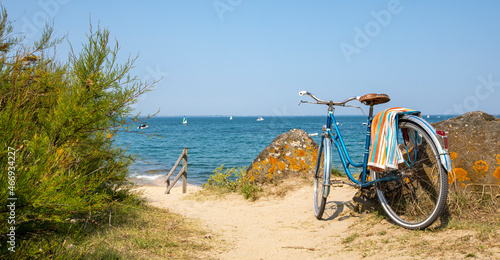 Vieux vélo bleu en bord de mer sur le littoral Français.