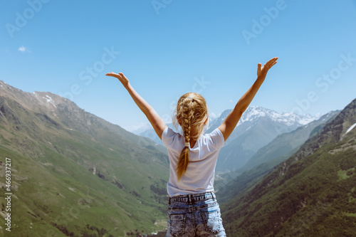 Happy preteen girl hiking on caucasian mountains in summer.