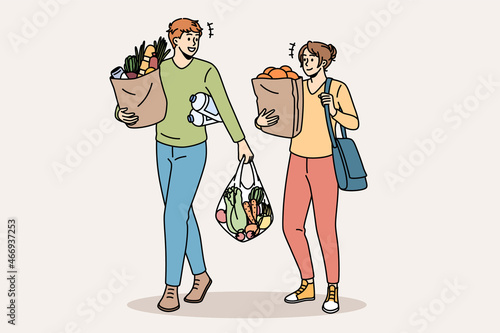 Shopping and buying fresh food concept. Young smiling couple man and woman cartoon characters walking carrying fresh food after going to grocery store vector illustration 