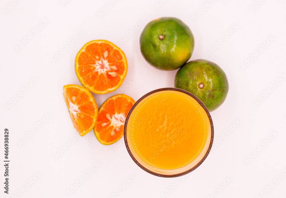 1 full glass of orange juice with 2 orange and sliced fruits isolated on white background. 100 % Orange juice. on top view. 1 full glass of orange juice with 2 orange and sliced fruits isolated on white background. 100 % Orange juice. on top view.