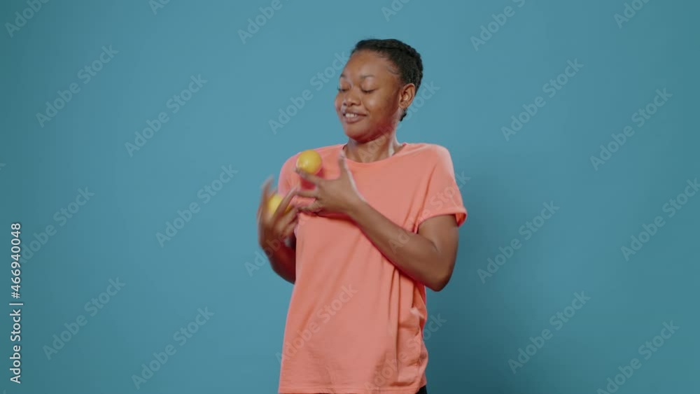 Positive woman juggling with fresh lemons and smiling in front of camera. Young adult trying to juggle with yellow citrus fruits, advertising organic and natural vitamins. Funny vegetarian Positive woman juggling with fresh lemons and smiling in front of camera. Young adult trying to juggle with yellow citrus fruits, advertising organic and natural vitamins. Funny vegetarian