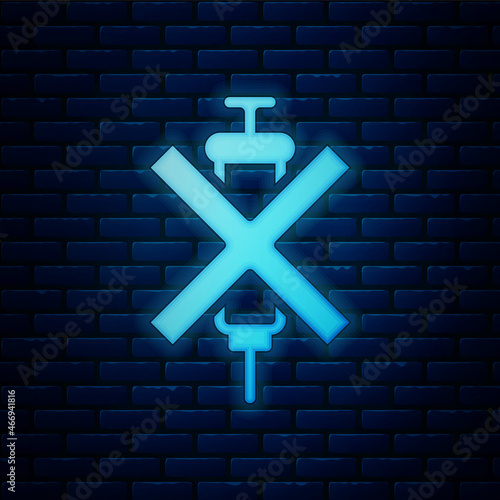 Glowing neon No doping syringe icon isolated on brick wall background. Vector