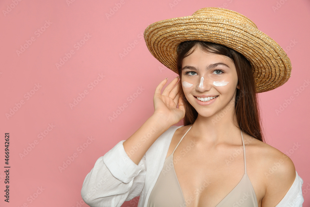 Teenage girl with sun protection cream on her face against pink background. Space for text Teenage girl with sun protection cream on her face against pink background. Space for text
