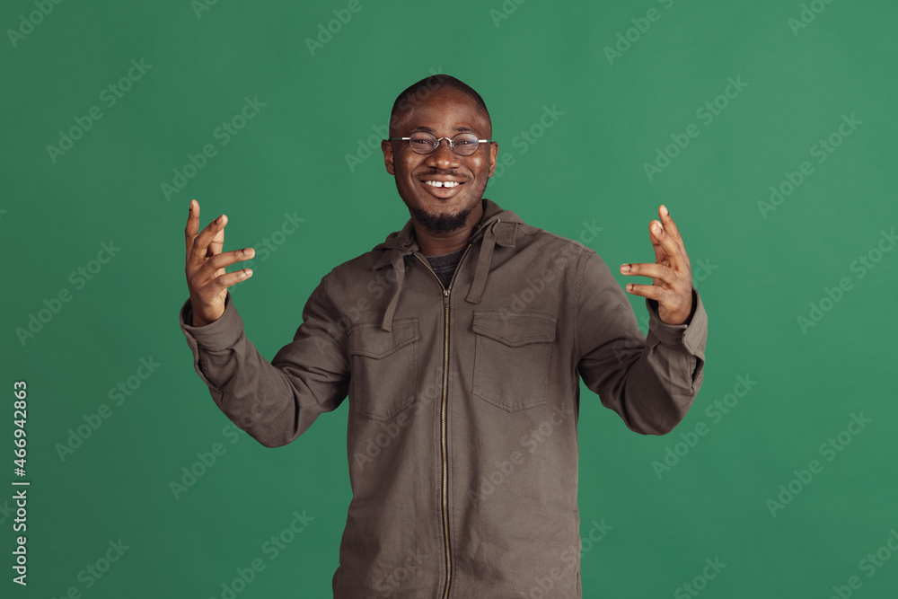 Winning success happy man celebrating being a winner. Dynamic image of male model isolated on dark green studio background Winning success happy man celebrating being a winner. Dynamic image of male model isolated on dark green studio background