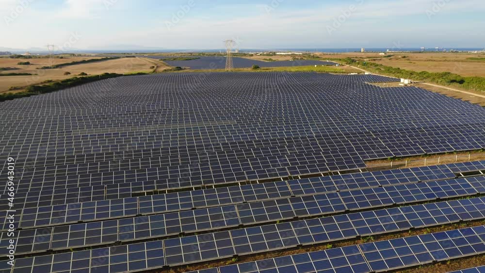 Drone panorama shot of a solar farm, a large collection of solar panels, surrounded by plowed fields. Drone panorama shot of a solar farm, a large collection of solar panels, surrounded by plowed fields.
