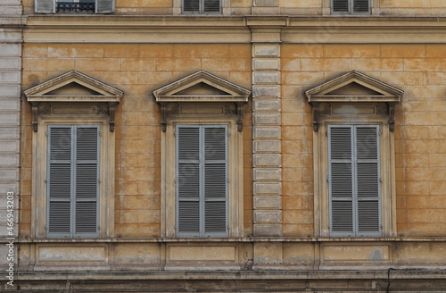 Traditional Building Facade Detail with Windows and Grey Shutters in Rome, Italy