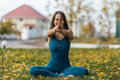 girl in blue clothes doing yoga exercises in the autumn park