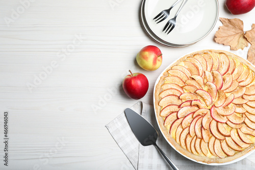 Flat lay composition with tasty apple pie on white wooden table, space for text