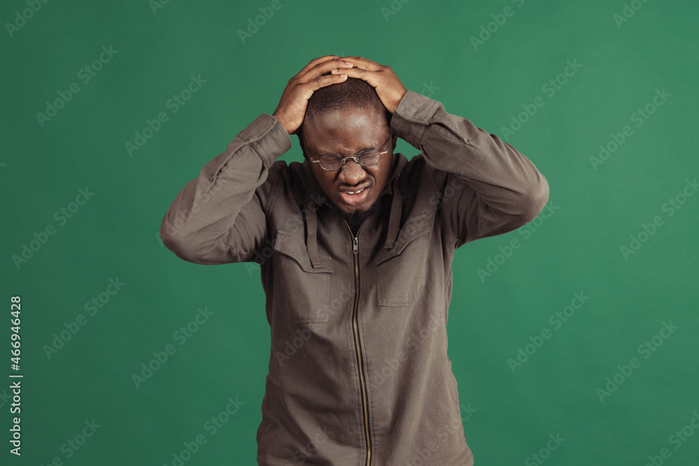 One young stylish african man wearing casual clothes isolated on navy studio background. Emotions, facial expression concept. One young stylish african man wearing casual clothes isolated on navy studio background. Emotions, facial expression concept.