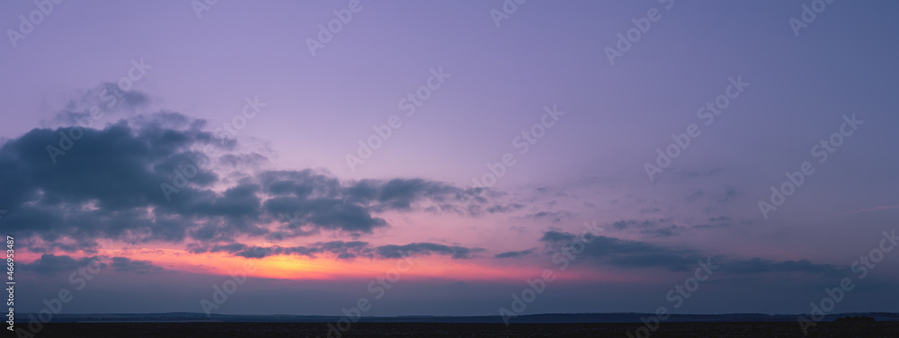 Purple sunset with the sun behind the clouds. Colorful cloudy sky at sunset. Gradient color. Sky texture, abstract nature background