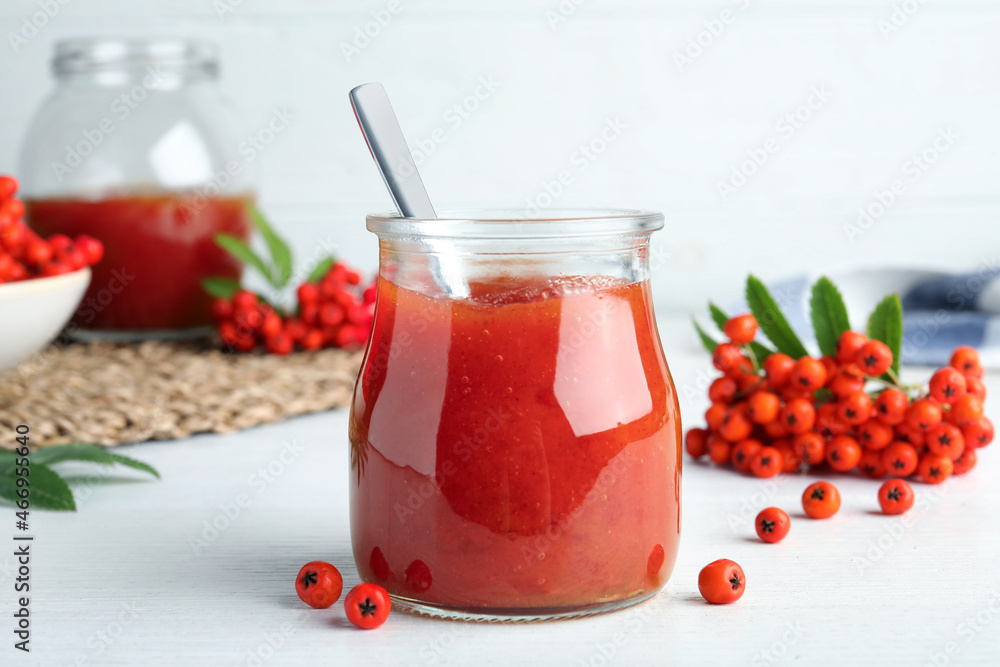 Delicious rowan jam in glass jar on white wooden table Delicious rowan jam in glass jar on white wooden table