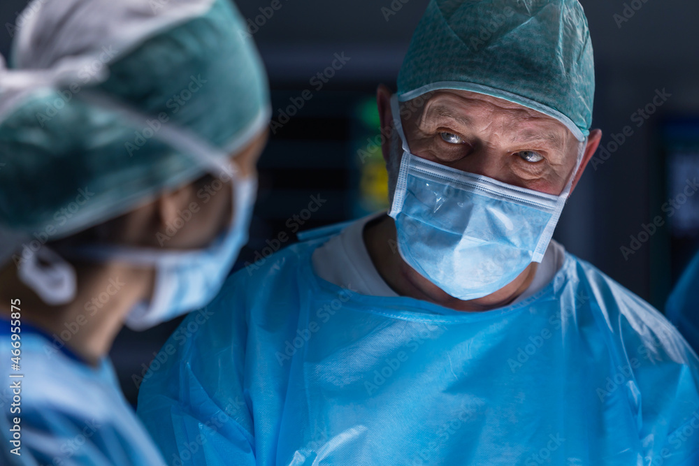 Multiracial team of professional medical surgeons performs the surgical operation in a modern hospital. Doctors are working to save the patient. Medicine, health, cardiology and transplantation. Multiracial team of professional medical surgeons performs the surgical operation in a modern hospital. Doctors are working to save the patient. Medicine, health, cardiology and transplantation.