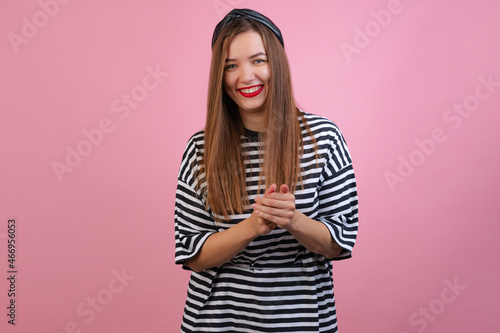 Portrait of young beautiful girl looking at camera isolated on light pink studio background. Concept of emotions, fashion