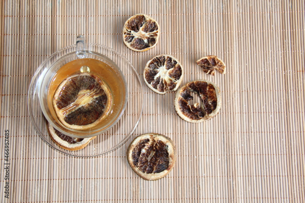 Orange tea in a transparent cup on a bamboo mat. View from above. Orange tea in a transparent cup on a bamboo mat. View from above.