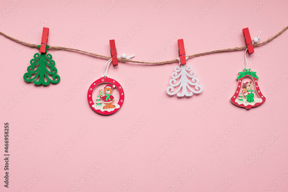 Christmas tree toys on a string on a pink background. Christmas concept