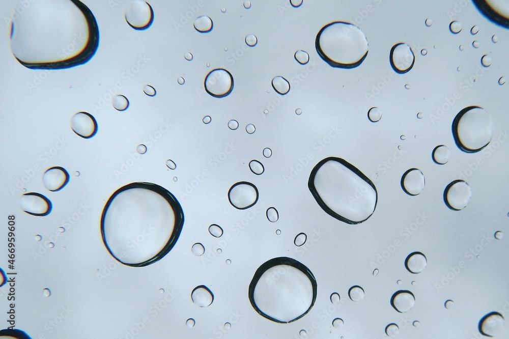 Closeup of Clear Raindrops on Windshield under Cloudy Gray Sky