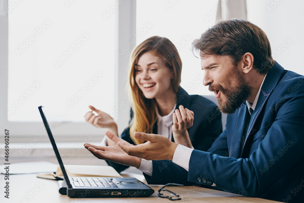 business man and woman sitting at a desk with a laptop communication professionals business man and woman sitting at a desk with a laptop communication professionals