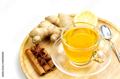 Glass of tea with ginger, lemon, cinnamon sticks and star anise isolated on white background.
