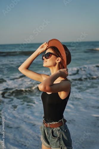 woman walking on the beach hat travel vacation sun