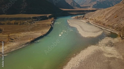 Altai Republic, Siberia, Russia. The two rivers Biya and Katun join into one river. Landscape with autumn wildlife: huge mountains, stone coast, yellow trees with golden foliage, green turquoise river photo