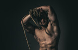 Muscular shoulders. Masculinity, power and strength. Healthy muscular young man with rope.