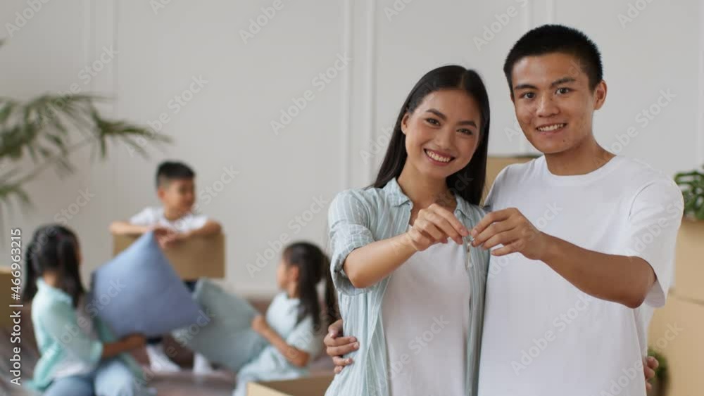Happy Asian Couple Showing New Home Key Hugging Indoors Happy Asian Couple Showing New Home Key Hugging Indoors