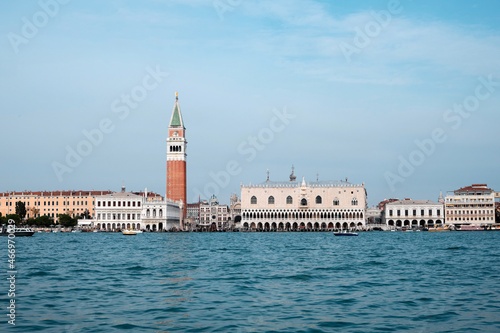 Doge's palace and Campanile on Piazza di San Marco, Venice, Italy with reflection. View from passing vaporetto boat, with sea water of Venice Lagoon in front.