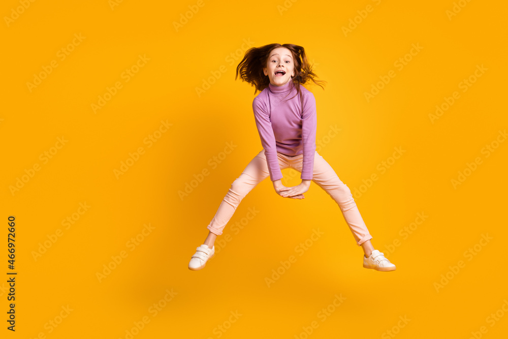 Full length body size view of attractive funny girlish cheerful girl jumping having fun fooling isolated over bright yellow color background Full length body size view of attractive funny girlish cheerful girl jumping having fun fooling isolated over bright yellow color background