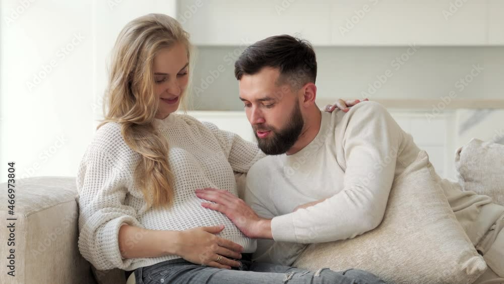 Smiling man strokes his pregnant wife's tummy. Pregnant woman and husband holding each other's hands. The concept of healthcare and the love of pregnancy. Smiling man strokes his pregnant wife's tummy. Pregnant woman and husband holding each other's hands. The concept of healthcare and the love of pregnancy.
