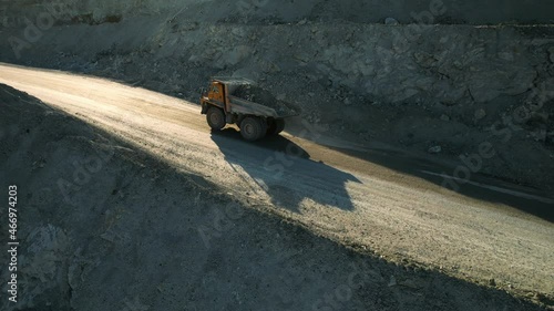 Career dump truck goes in a gold mine. Aerial view of large mining trucks on a gold mine. Open pit mine quarrying extractive industry stripping work. photo