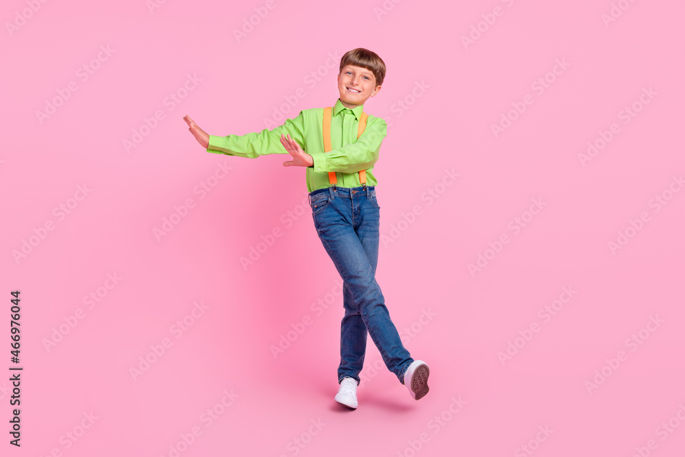 Full length body size view of attractive cheerful carefree boy walking dancing isolated over bright pink color background Full length body size view of attractive cheerful carefree boy walking dancing isolated over bright pink color background
