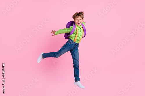 Full length body size view of handsome trendy boy jumping having fun isolated over pink pastel color background
