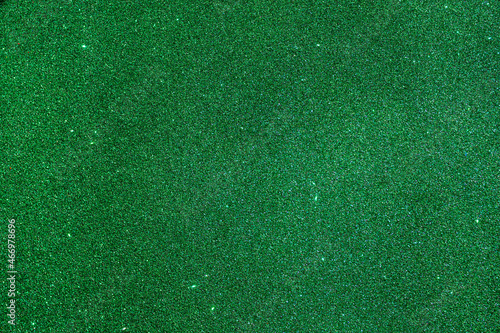 Bright green shiny background with yellow dots and stars. Green Christmas tree color. Christmas background. Christmas green for your photos